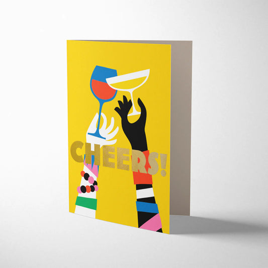 Bright Yellow card depicting two people's arms adorned with bright coloured jewellery. Clinking a glass of fizz and a glass of red wine together. A graphic illustration. With the word CHEERS!! printed across the middle of the card in gold litho lettering.