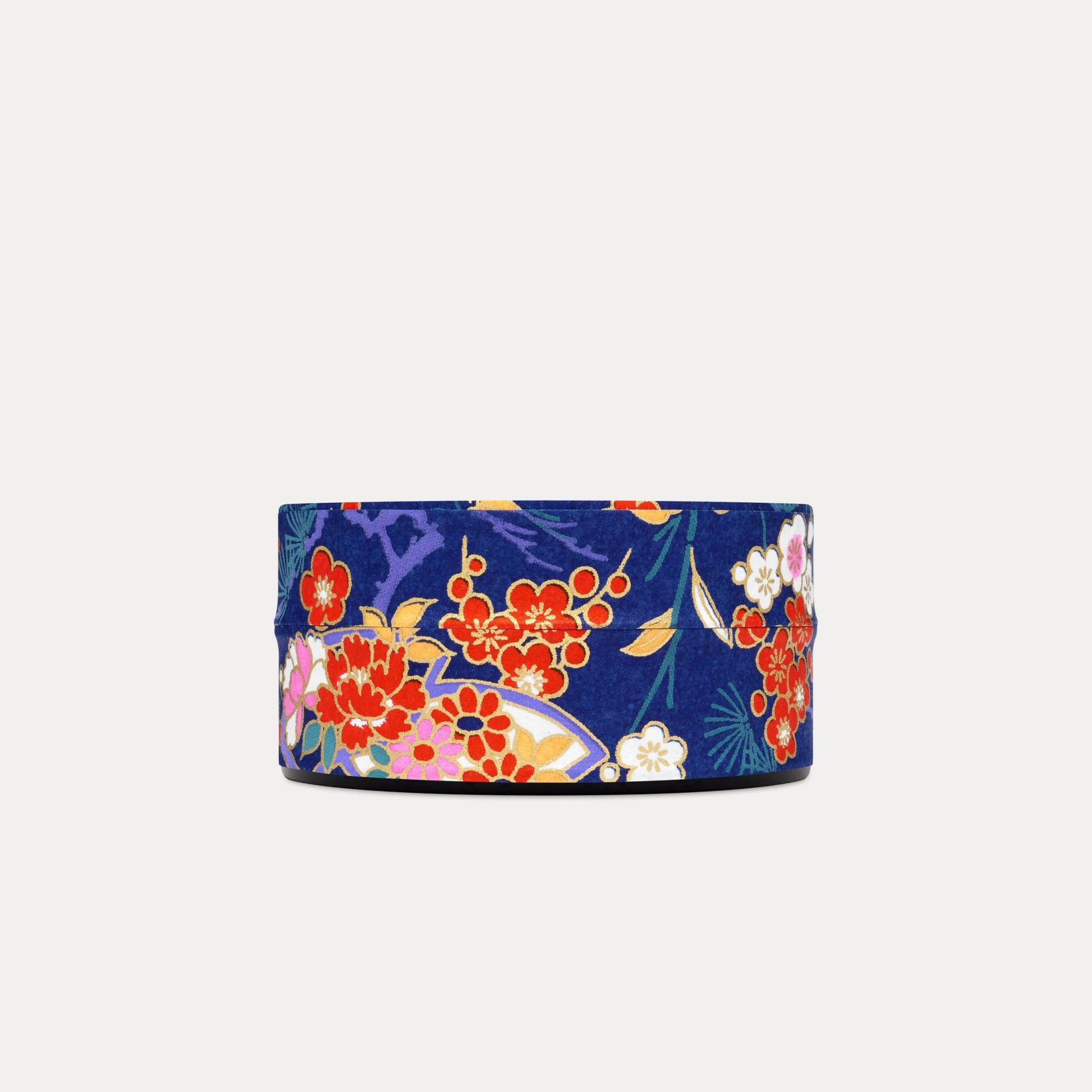 Red Blossom / Cobalt Blue Keepsake tin features a striking contrast of vermillion red blossom against a rich cobalt blue background . The reaching branches and organic shape of the fans lead you across the design, intersperred with bamboo leaves. Each of our designs are selected from an archive of designs in Kyoto Japan, where we work with family-run silk screen print studios to produce our covering papers. This paper features a gold accent screen, that gives it that truly opulent finish.