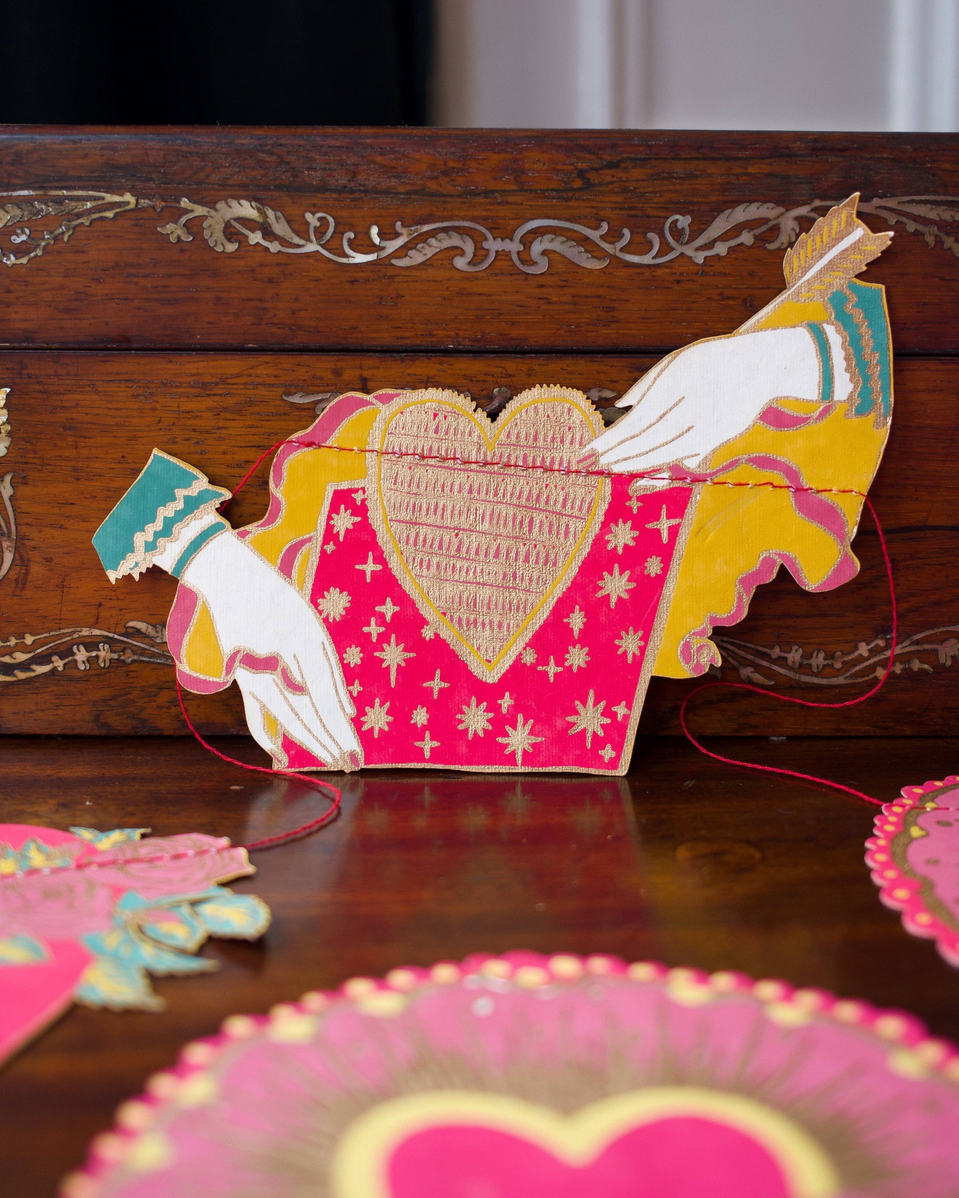 Inspired by scared hearts and Mexican folk art, this garland is full of kitsch and romance. Ten decorative, bejewelled hearts create the three metre garland.

Includes 10 paper shapes, sewn along strong cotton thread - Screen printed by hand on both sides by talented artisans in Jaipur - Sustainably made from recycled materials