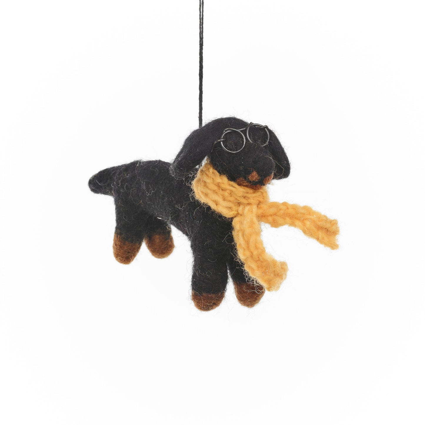 Meet Douglas, the dapper dachshund with a flair for fabulousness. With his sleek black coat and long, elegant body, his knitted yellow scarf wrapped around his neck and round wire glasses perched on his nose, Douglas is the epitome of four-legged fashion. Hanging Christmas decoration.