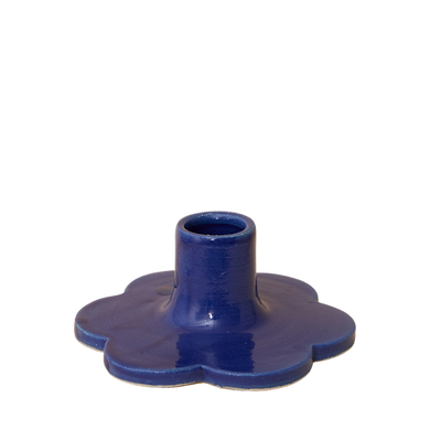 Handcrafted Solo Flower Candle Holder - Blue. Handcrafted from stoneware clay, this colourful candle holder is ideal as a decorative focal point for your dining table, mantlepiece or nightstand. The base is in the shape of a flower. 10cm wide x 4cm high