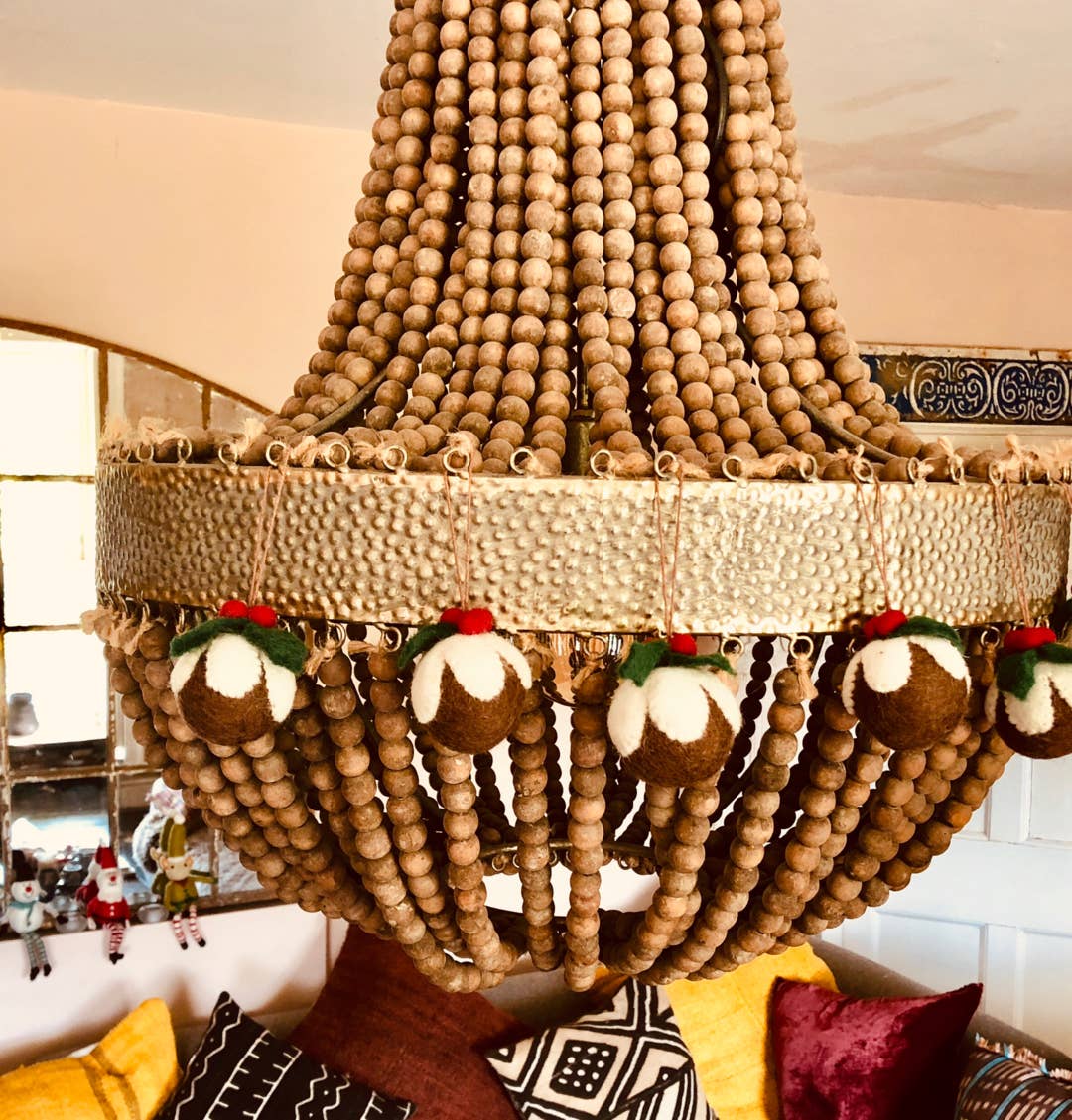 Christmas Pudding decorations shown hanging from a chandelier.