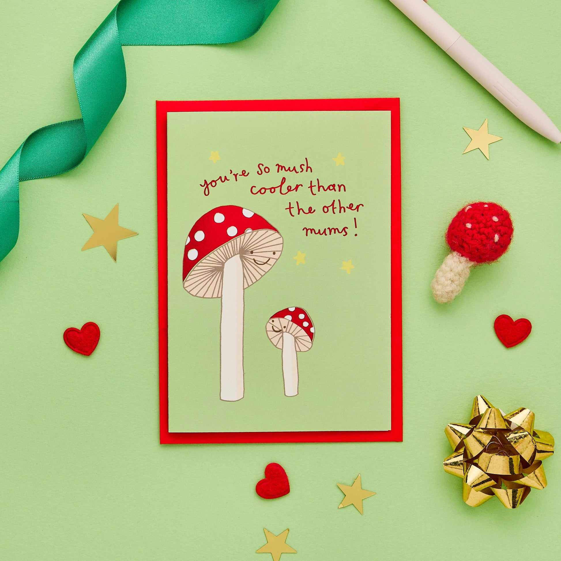 Stunning mum card perfect for a female birthday or Mothers Day message. Beautiful, original hand drawn design featuring a mushroom mum alongside her mini mushroom, painted in striking colours.

Written in a lovely, original hand lettered font and finished with gold foil, the endearing message on the front of this unique greeting card reads "You're so mush cooler than the other mums"