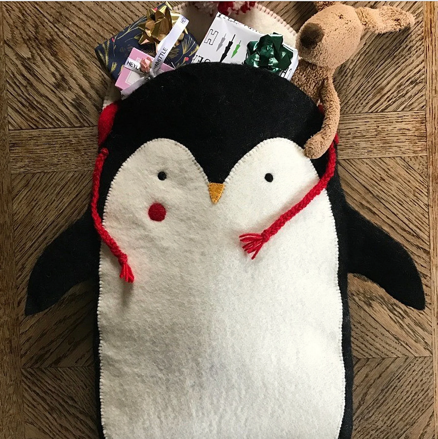 Red Pete the Penguin Felt Stocking for kids. Wearing a white and red hat with a woolly pom pom. Sustainably made.