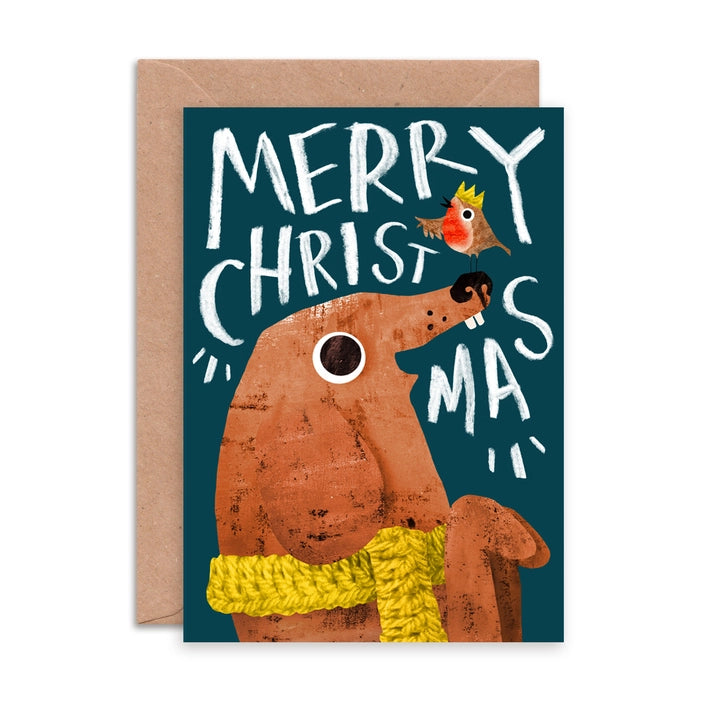 Illustrated Christmas greeting cards by Emily Nash Illustration. With the words Merry Christmas. featuring a robin in a Christmas hat, presenting a gift to his friend a dog in a mustard cosy scarf. 