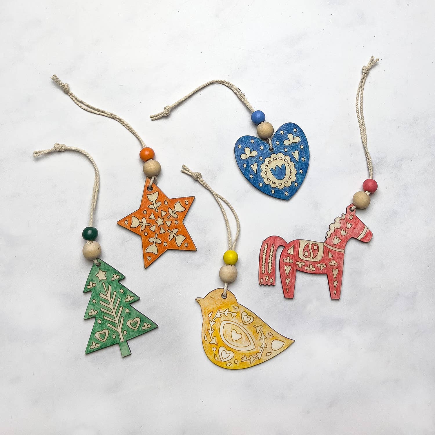 Folk Art Decoration kit. The finished wooden decorations, a Christmas tree, star, heart , bird and horse.