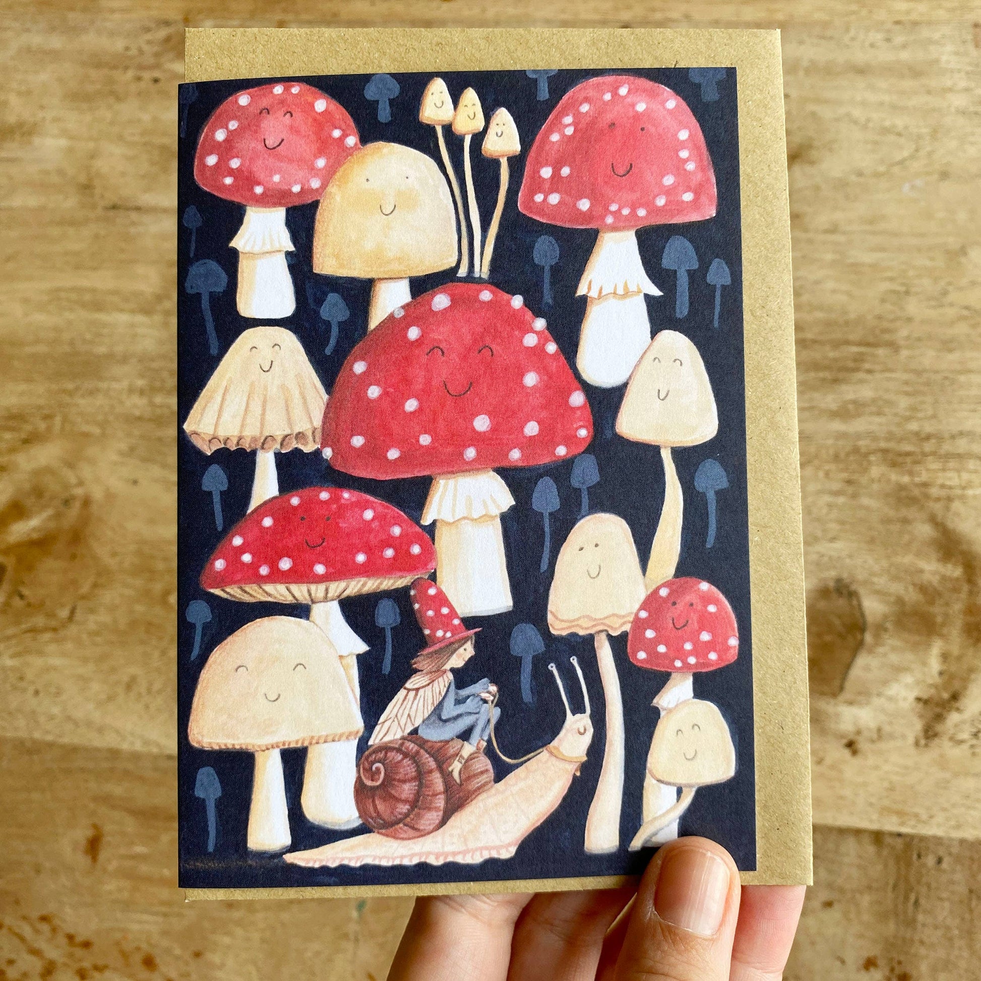 Elf riding a snail in a toadstool forest greetings card