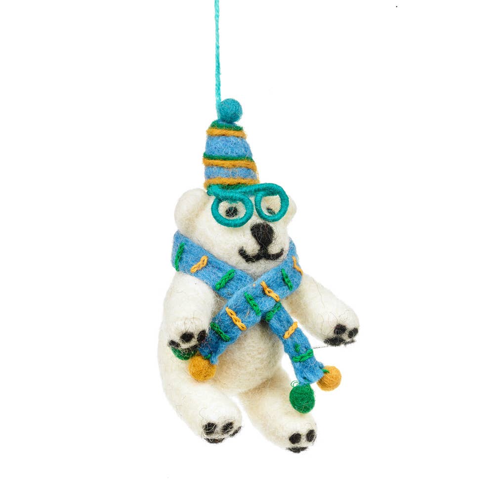 Handmade Felt Cosmo the Polar Bear Decoration. Wearing a blue scarf with green and yellow stripes and pom poms. A matching hat and green glasses.