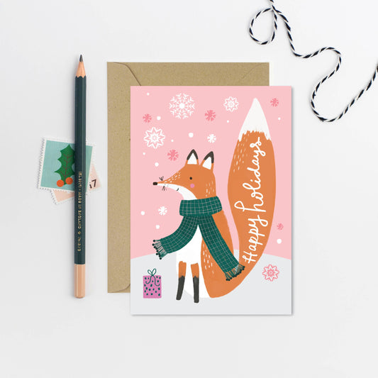 Happy Holidays Fox Card. The little fox on this holiday card is all ready for the winter weather, wearing a cowy green scarf to brace against the drifting flakes of snow. The red fox’s tail has been inscribed with the Christmas card’s caption, reading “Happy Holidays”, making it perfect for all seasonal celebrations.