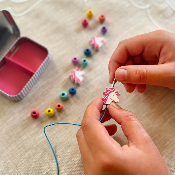 Unicorn Bracelet Craft It. A beautiful gift tin containing elastic and beads to create a unicorn bracelet. The elastic comes with metal ends to aid the beading process for young children. The tin can be used to store the bracelet, or a special trinket.