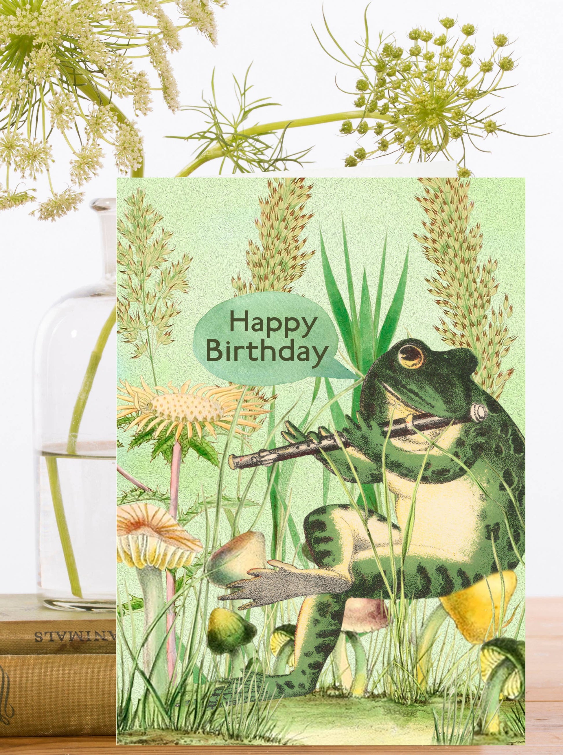 A green frog with a flute is ready to serenade you on your special day with this vintage-inspired birthday card.