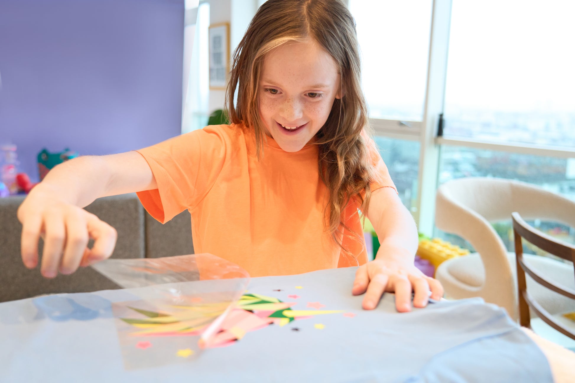 A child putting together the various coloured pieces of the peel and print Pop Kit Unicorn kit.