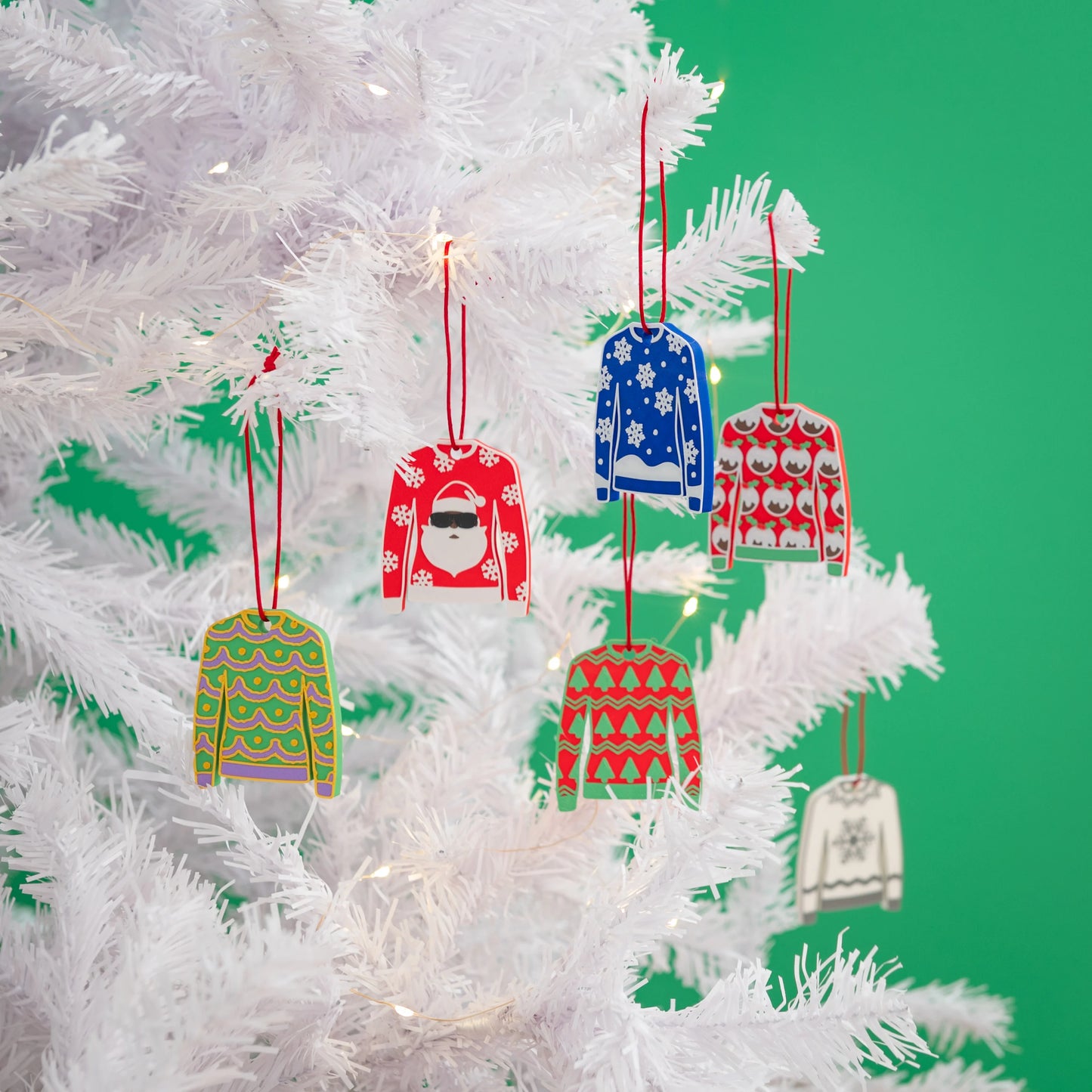 A collection of Made Happy Christmas jumper designs on a white Christmas Tree.