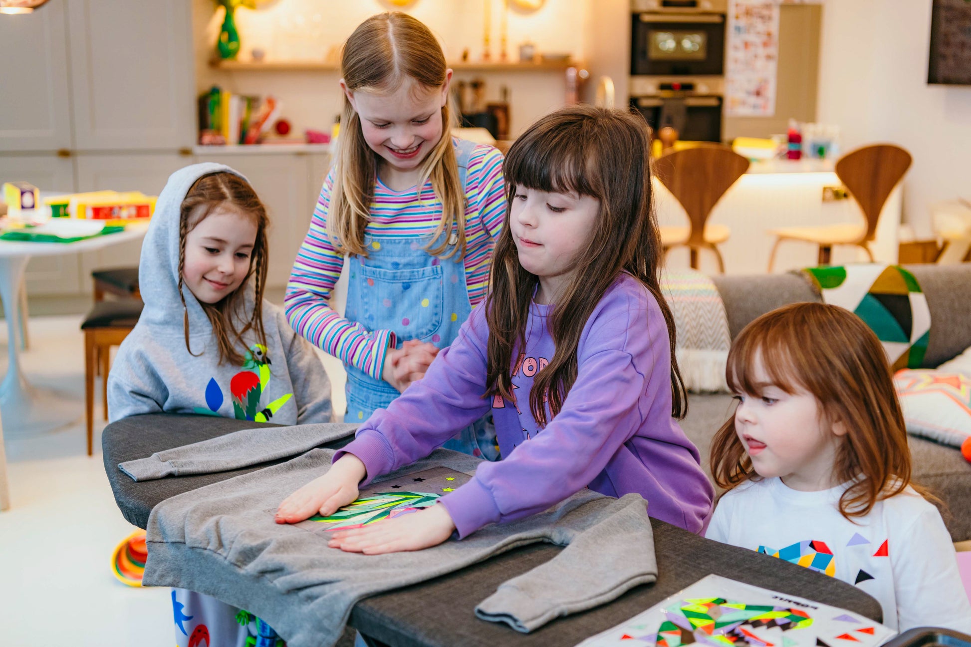 A group of young girls, with their Popkit creations on jumpers and hoodies.