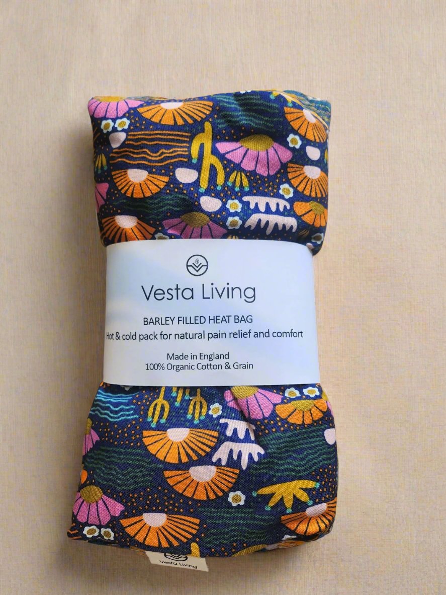 Vesta Living Barley Filled Wheat bag in a flowery print of pink, orange flowers and navy background.