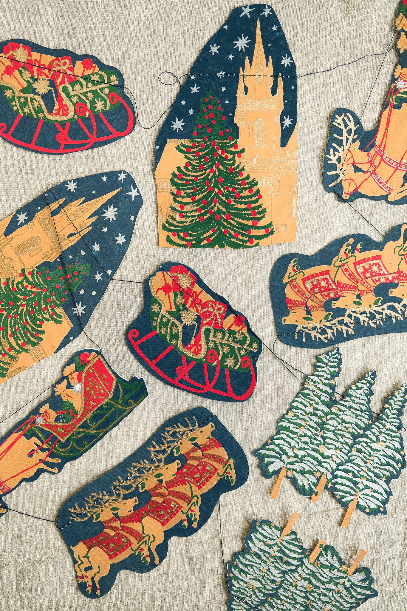 With traditional church steeples, snow tipped fir trees and Santa's sleigh, this garland features ten charming Christmas images of a festive night time skyline.

3 metres long

Includes 10 paper shapes, sewn along strong cotton thread