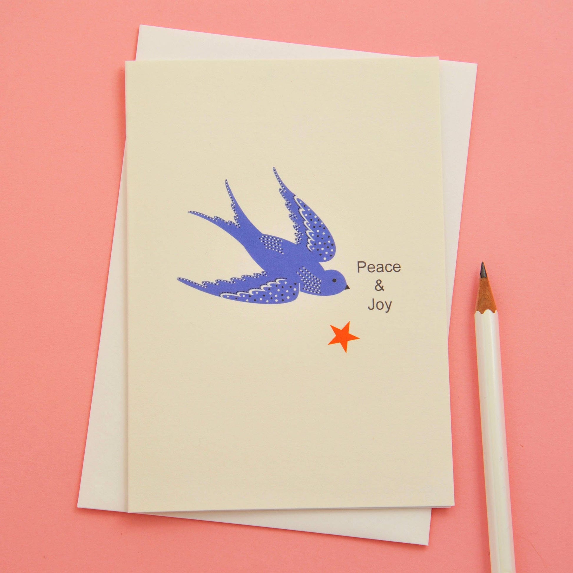 Simple Christmas card depicting a blue dove, a red star and the words Peace & Joy against a white background.