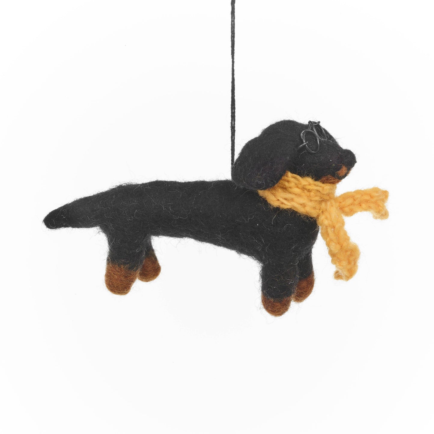 Meet Douglas, the dapper dachshund with a flair for fabulousness. With his sleek black coat and long, elegant body, his knitted yellow scarf wrapped around his neck and round wire glasses perched on his nose, Douglas is the epitome of four-legged fashion. Hanging Christmas decoration.