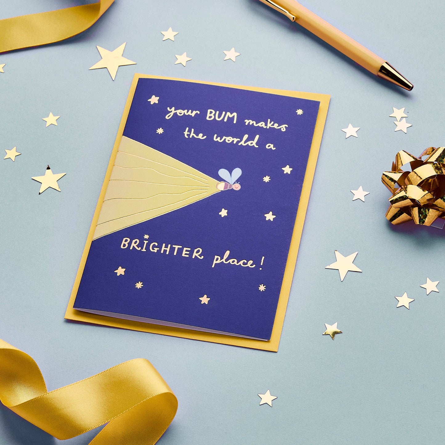 An authentic, one of a kind greeting card baring a humorous, tongue in cheek message. The original, hand drawn design of a glowing firefly is just waiting to light up someone's day.

Printed in the UK on sustainably sourced premium, recyclable paper. Written in a striking, hand lettered font and finished with gold foil, the message on the front of this wonderfully witty greeting card reads "Your BUM makes the world a BRIGHTER place".