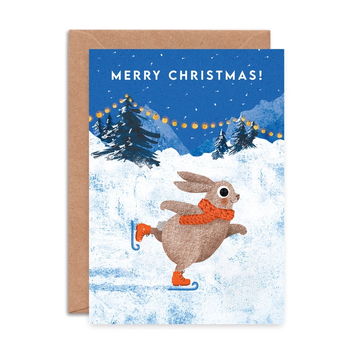 Illustrated Christmas greeting cards by Emily Nash Illustration. Snowy scenes of a rabbit in a woolly scarf enjoying ice skating in a snowy Christmas scene. With the words Merry Christmas!