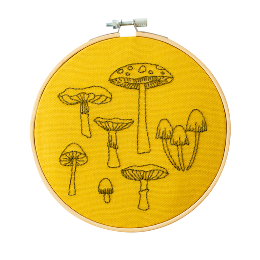 Yellow Fungi Embroidery Hoop Kit Kit by Cotton Clara. Featuring  seven different fungi's in black thread to embroider.