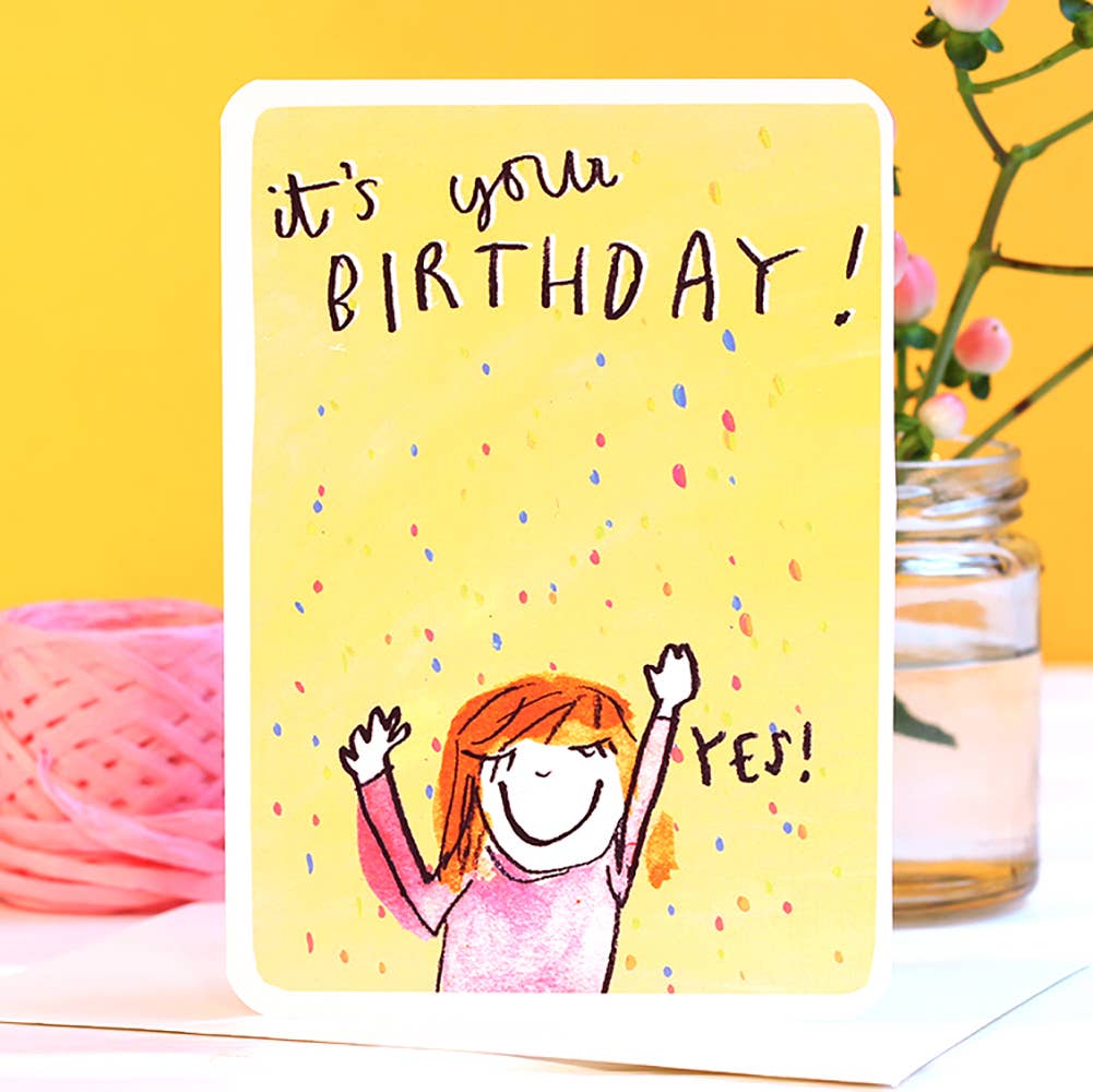 Give yourself a high five, friend! It's your birthday! This adorable illustrated card is the perfect way to celebrate a friend's special day. This cute card, features a smiling woman pumping the sky with the word Yes! It's your birthday written at the top of card with a yellow background with coloured confetti.