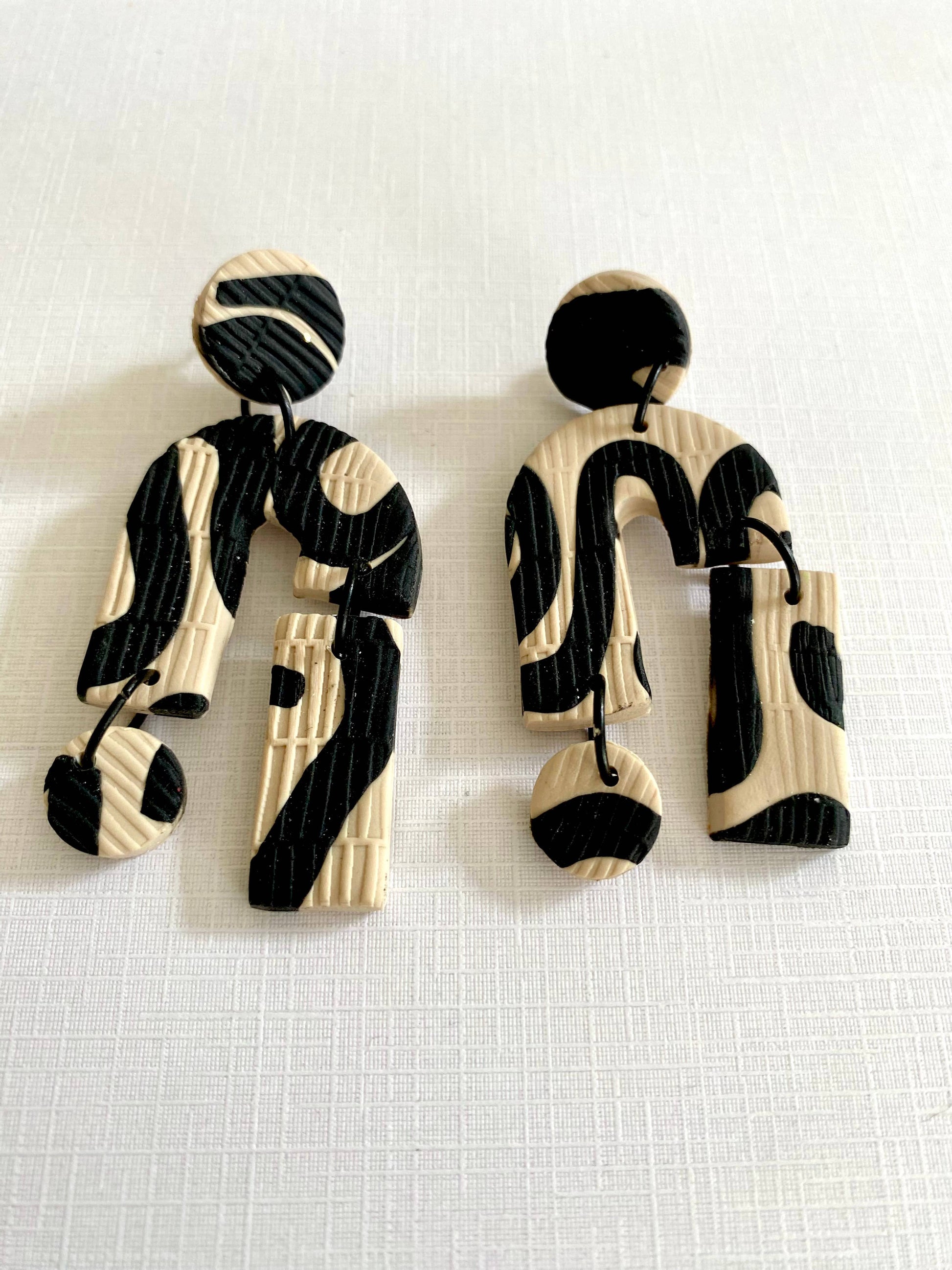 Beige &amp; Black polymer clay statement drop earrings.&nbsp;

Aboriginal women create baskets and containers to carry food and other items. These include soft string bags or dilly bags made from woven bush string and stiff baskets made from bulrushes, strips of palm fronds, and strips of cane. As they weave, they yarn and collect each other’s stories. This is a sacred time, and when finished, the basket carries not only their nourishment, but their community and spirit.