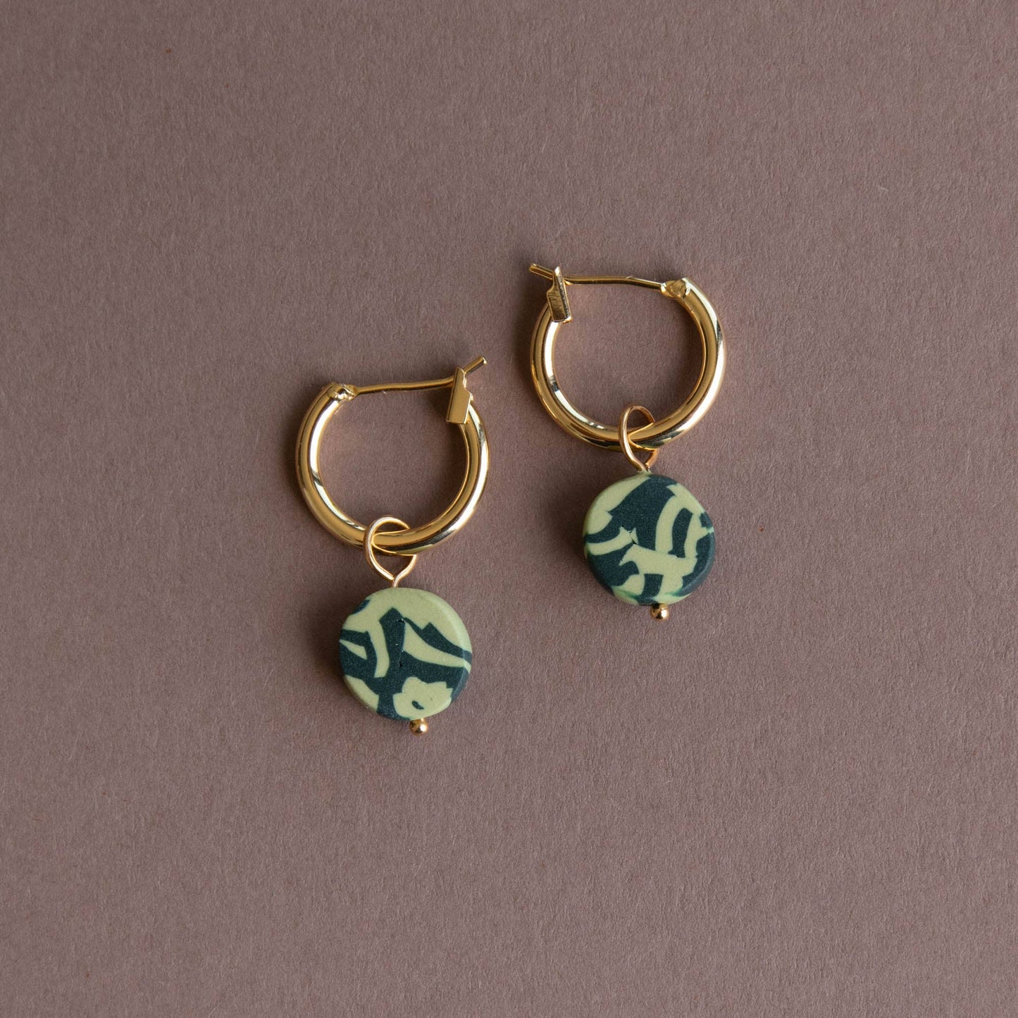 Bits Circle Charm Hoop Earrings. Gold  plated nickel free earring hoops. With a circle of handmade pigmented clay which is mixed together to create this fun jumbled pattern. Shown in Forest and Apple Green.