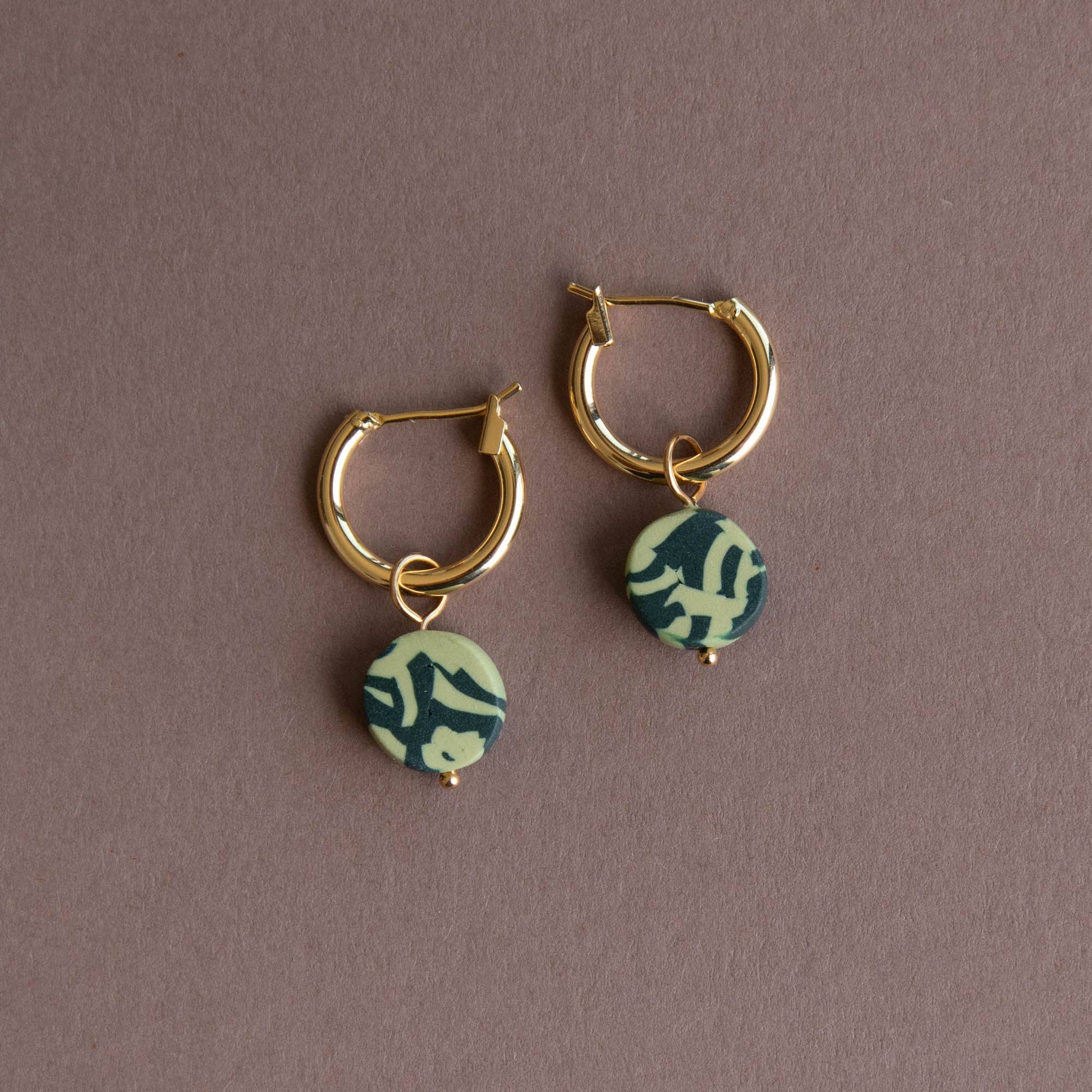 Bits Circle Charm Hoop Earrings. Gold  plated nickel free earring hoops. With a circle of handmade pigmented clay which is mixed together to create this fun jumbled pattern. Shown in Forest and Apple Green.