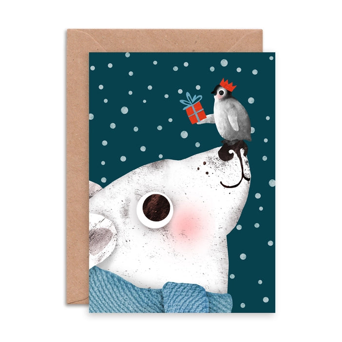 Illustrated Christmas greeting cards by Emily Nash Illustration. With the words Merry Christmas. featuring a penguin in a Christmas hat, presenting a gift to his friend a polar bear in a blue cosy scarf. All the while the dark sky is filled with snow.