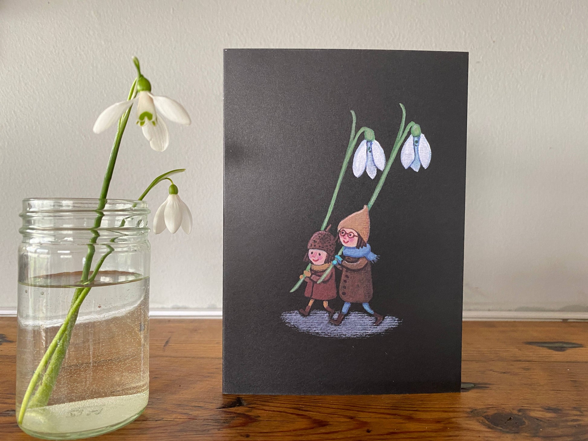 A hand painted illustration of Snowdrops, picked by tiny forest folk, printed onto 100% recycled card. Spring is just around the corner, the Snowdrops in my garden have brightened up my day, and the tiny forest folk featured in this sweet little illustration have been out picking them too.