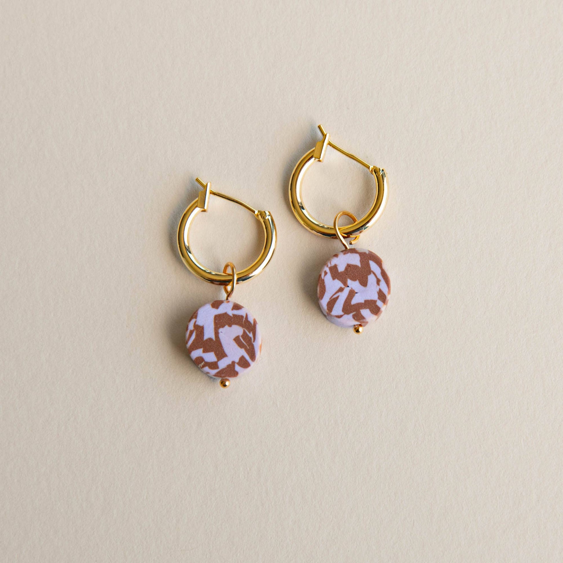 Bits Circle Charm Hoop Earrings. Gold  plated nickel free earring hoops. With a circle of handmade pigmented clay which is mixed together to create this fun jumbled pattern. Shown in Chocolate and Lilac.