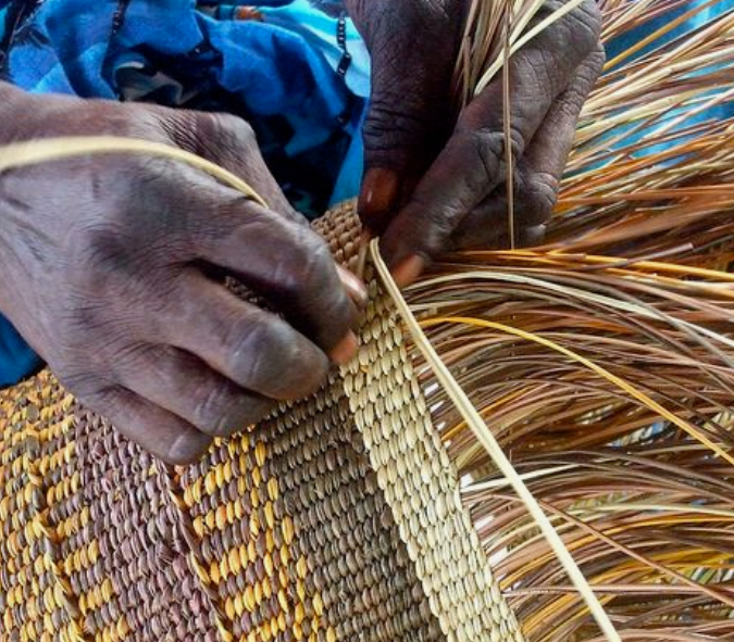 Aboriginal women create baskets and containers to carry food and other items. These include soft string bags or dilly bags made from woven bush string and stiff baskets made from bulrushes, strips of palm fronds, and strips of cane. As they weave, they yarn and collect each other’s stories. This is a sacred time, and when finished, the basket carries not only their nourishment, but their community and spirit.