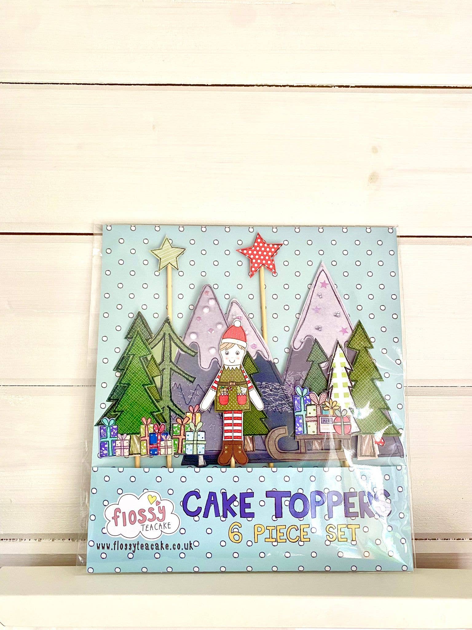 Elf Christmas Cake Topper. Flossy illustrates, prints and hand finishes everything here in the UK, and wants to make products to make you smile! This six-piece cake topper set is a great addition to a homemade or shop-bought cake!